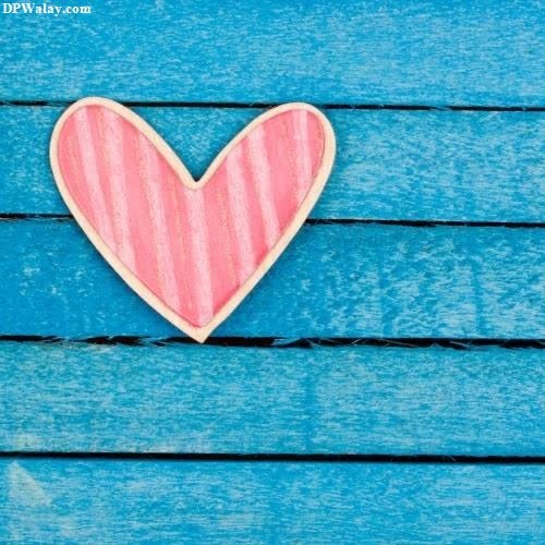 love dp for instagram - a heart shaped cookie on a blue wooden background