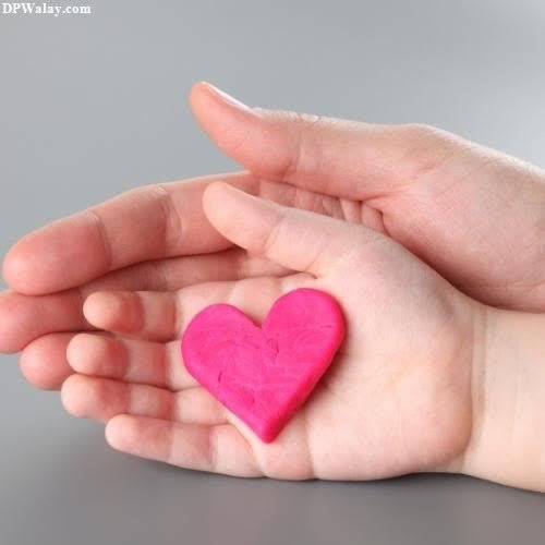 a pink heart in the palm of a child