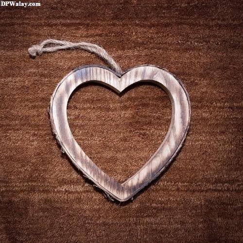 heart dp for whatsapp - a heart shaped wooden frame on a brown carpet