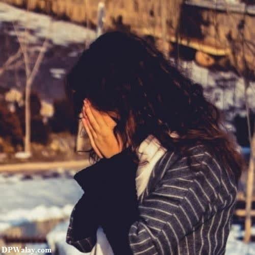 girls dp - a woman is standing in the snow with her hands on her face