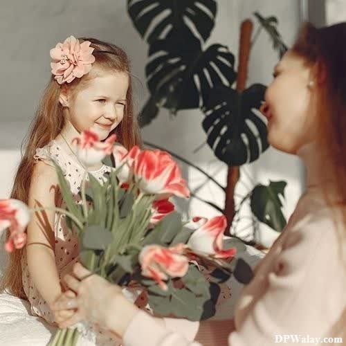 a little girl is holding flowers in her hands 