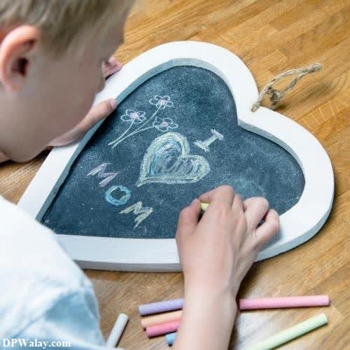 a young boy drawing on a chalk board mom dad images dp 