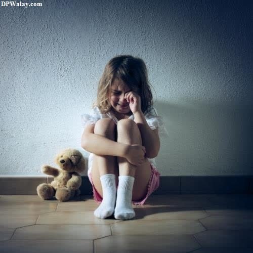 a little girl sitting on the floor with her teddy bear mood off do