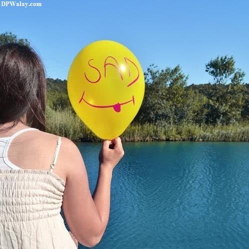 a woman holding a yellow balloon with a smiley face mood off do