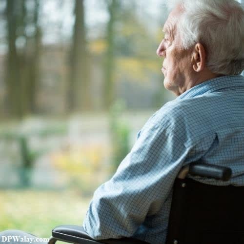 an elderly man sitting in a wheelchair looking out the window