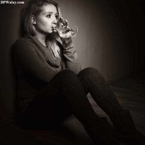a woman sitting on the floor drinking wine 