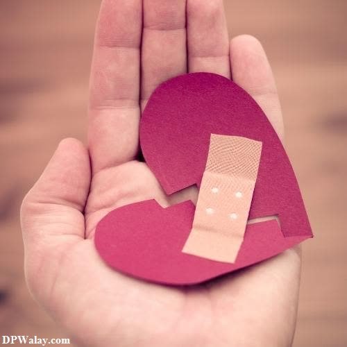 a hand holding a piece of paper with a heart cut in it