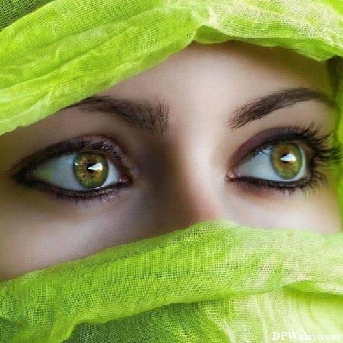 a woman with green eyes and a veil over her head