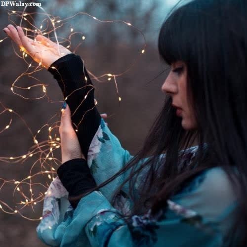 unique dp for whatsapp - a woman holding sparkles in her hands