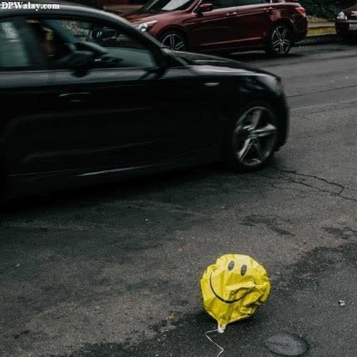 a yellow bag is on the ground next to a car 