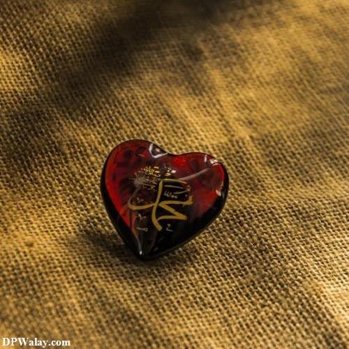 a heart shaped ring with a gold and red heart