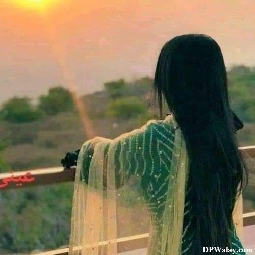 girls dp - a woman standing on a balcony looking out at the sunset