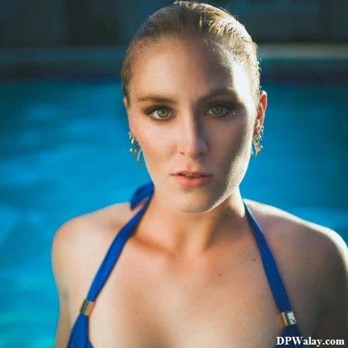 a woman in a blue bikini standing by a pool