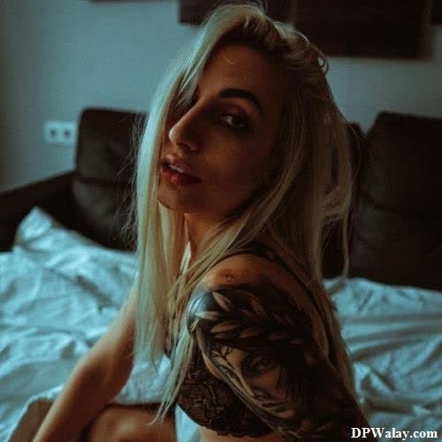 a woman sitting on a bed with a tattoo on her arm photos for girl dp 