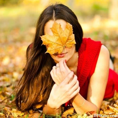 a woman laying on the ground with a leaf in her mouth images by DPwalay