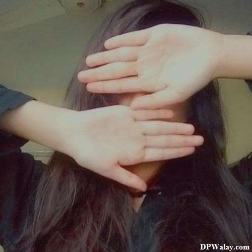 a woman with long hair is holding her hands over her head