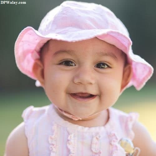 a baby girl wearing a pink hat and smiling pics whatsapp dp images