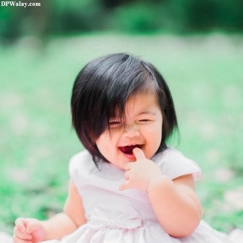 dp pic - a baby girl sitting on the grass with her mouth open
