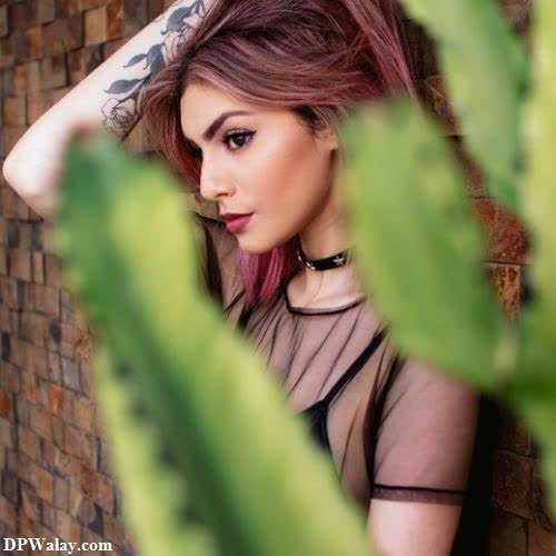 unique trendy dp for instagram - a woman with red hair and tattoos standing in front of a brick wall