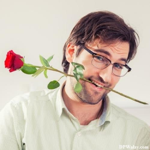 a man with glasses holding a rose in his mouth