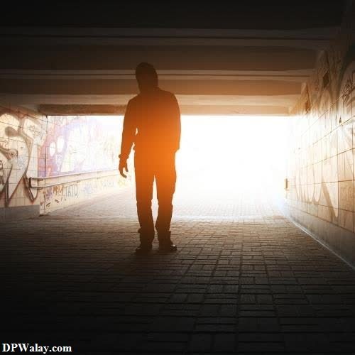 a person walking through a tunnel with the sun shining through sad female dp