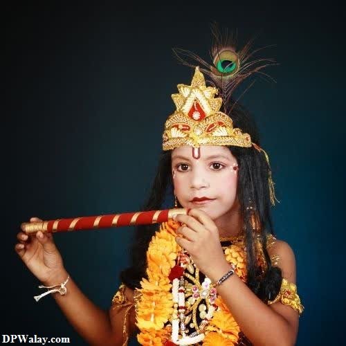krishna DP - a little girl in a costume holding a pipe