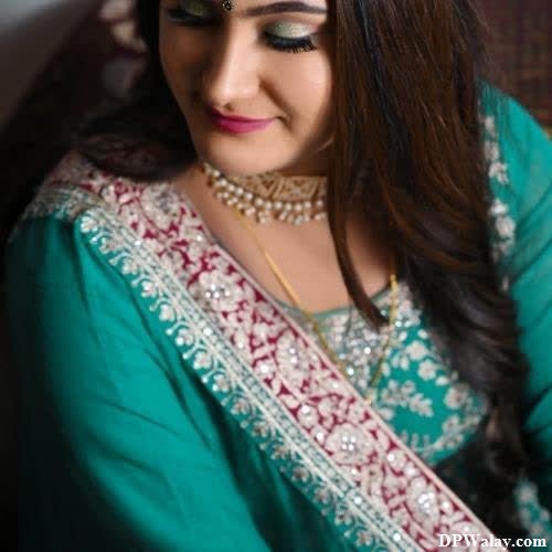 single girl dp - a woman in a green sari with a gold necklace