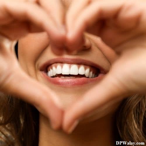 a woman making a heart with her hands smile images dp 