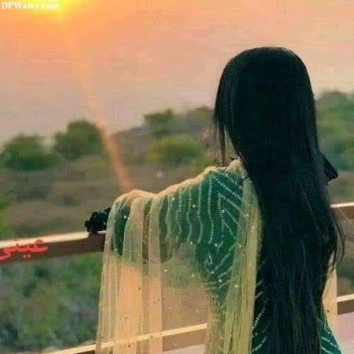 a woman standing on a balcony looking out at the sunset stylish hidden face dp