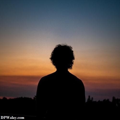 a silhouette of a person at sunset