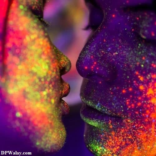 a couple kissing in the dark with colorful powder on their faces