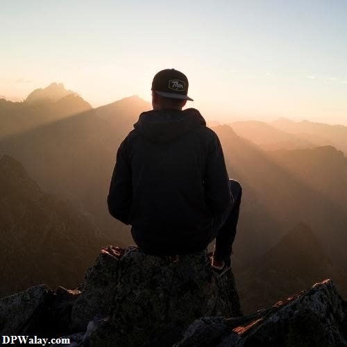 a man sitting on top of a mountain looking out at the sunset unique images for dp
