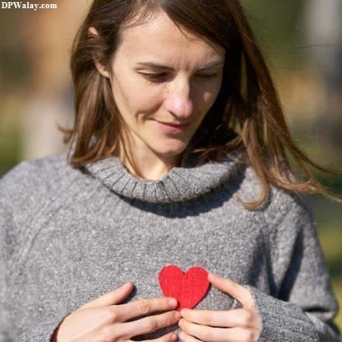 a woman holding a red heart in her hands-9kU3