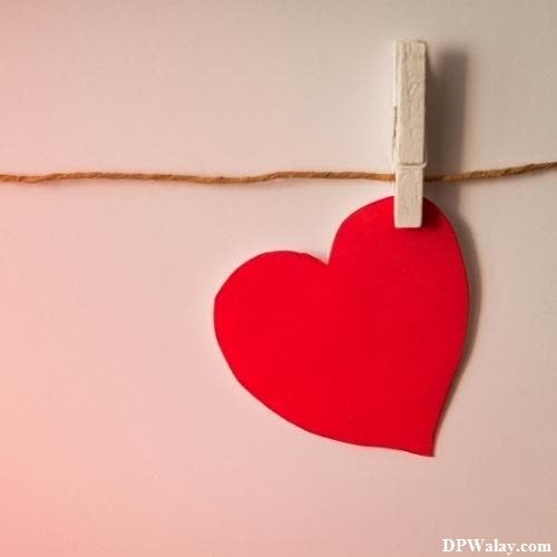 a heart hanging on a string with a red heart unique photo for whatsapp dp