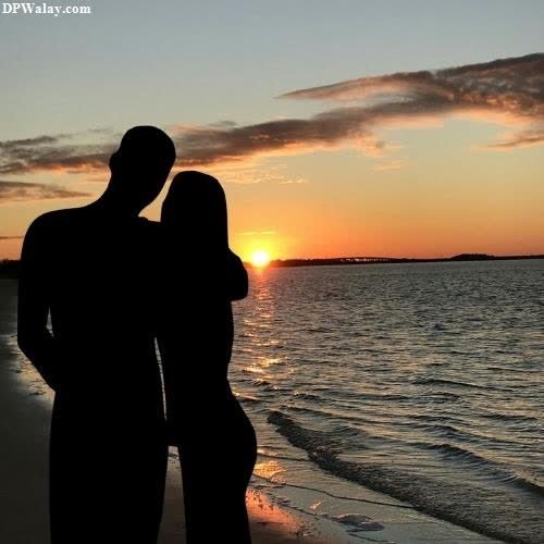 a couple kissing on the beach at sunset-g4OX