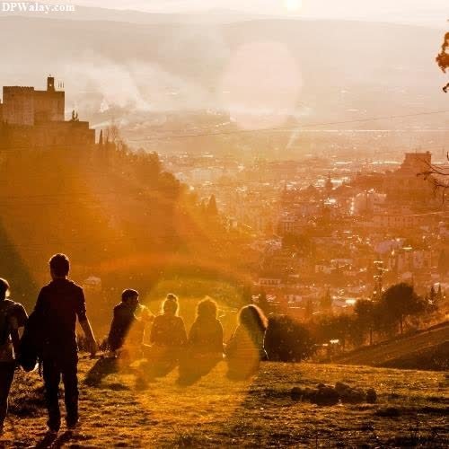 people walking on a hill with the sun shining 
