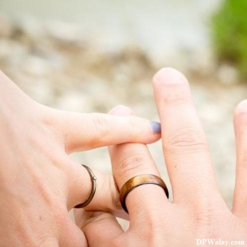 a couple holding hands with their wedding rings