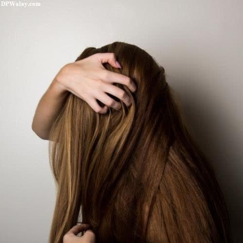 unique dp for whatsapp - a woman with long brown hair is holding her head