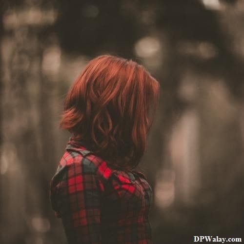 sad girl dp - a woman with red hair standing in the woods