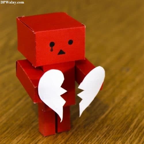 a red paper toy holding a heart images by DPwalay