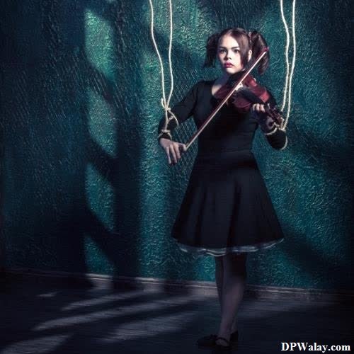 a girl in a black dress playing a violin