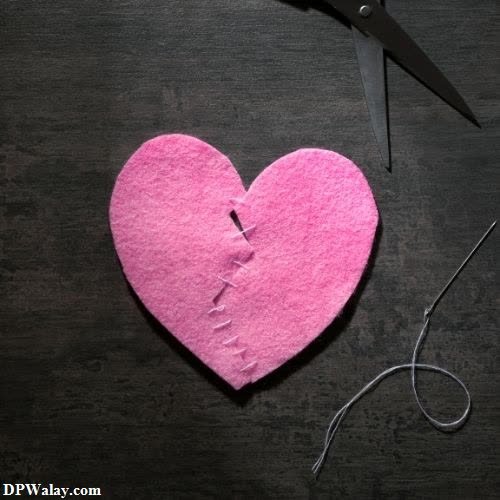 a pink heart with a pair of scissors next to it