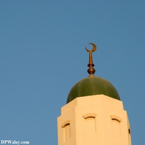 a white building with a green dome and a crescent on top 