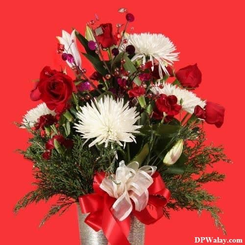 a vase filled with red and white flowers