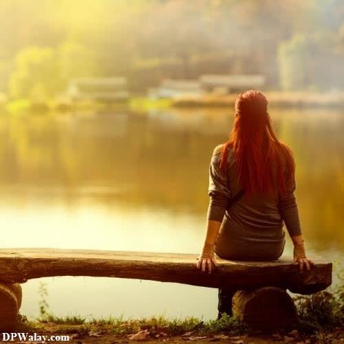 a woman sitting on a bench looking out over a lake whatsapp unique dp