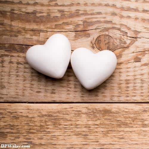 unique dp for whatsapp - two white hearts on a wooden background