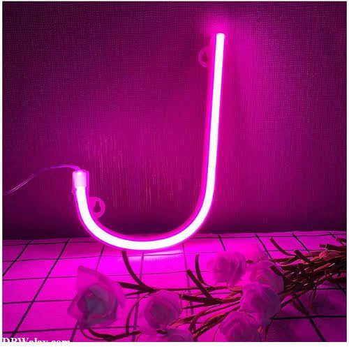 a pink neon sign with a flower in the background j name photo