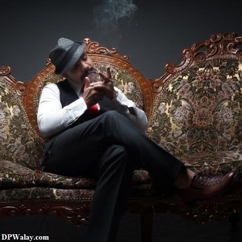 a man sitting on a couch smoking a cigarette bad boy attitude dp 