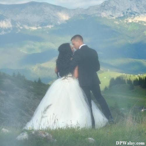 a bride and groom kissing in the mountains 