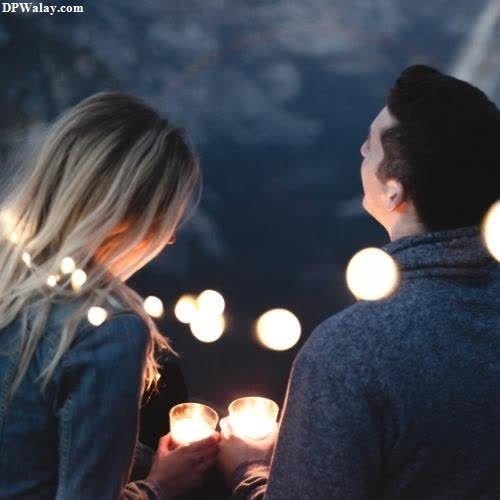 a couple holding candles in their hands